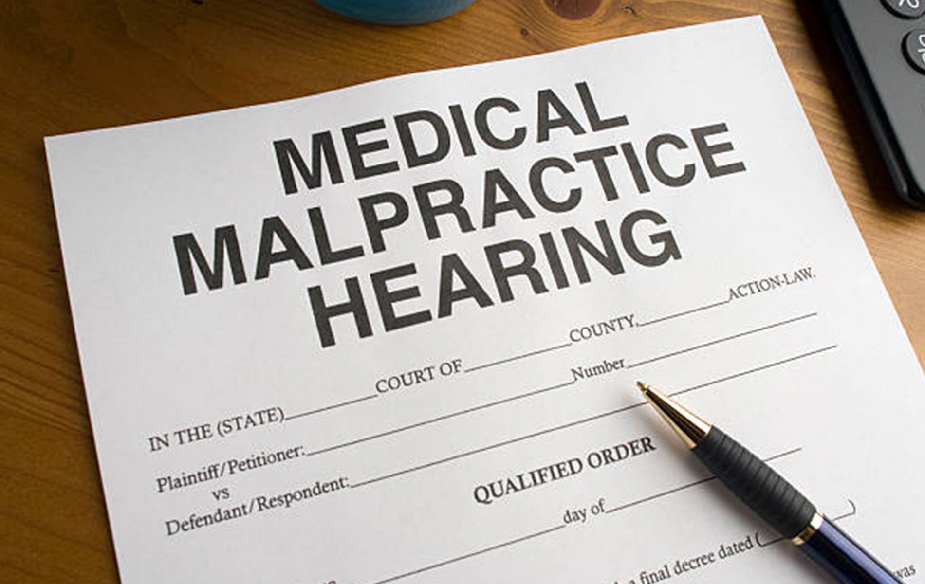 A pen is sitting on top of a medical malpractice hearing form