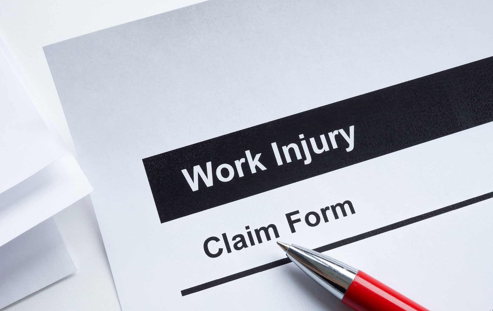 A pen is sitting on top of a work injury claim form