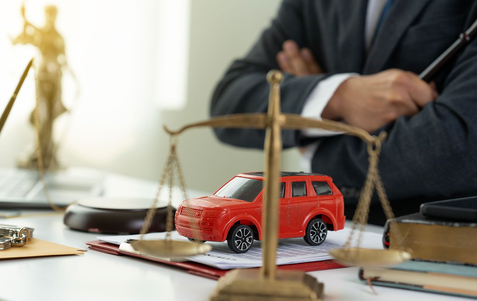 A man is sitting at a desk with a toy car on a scale.