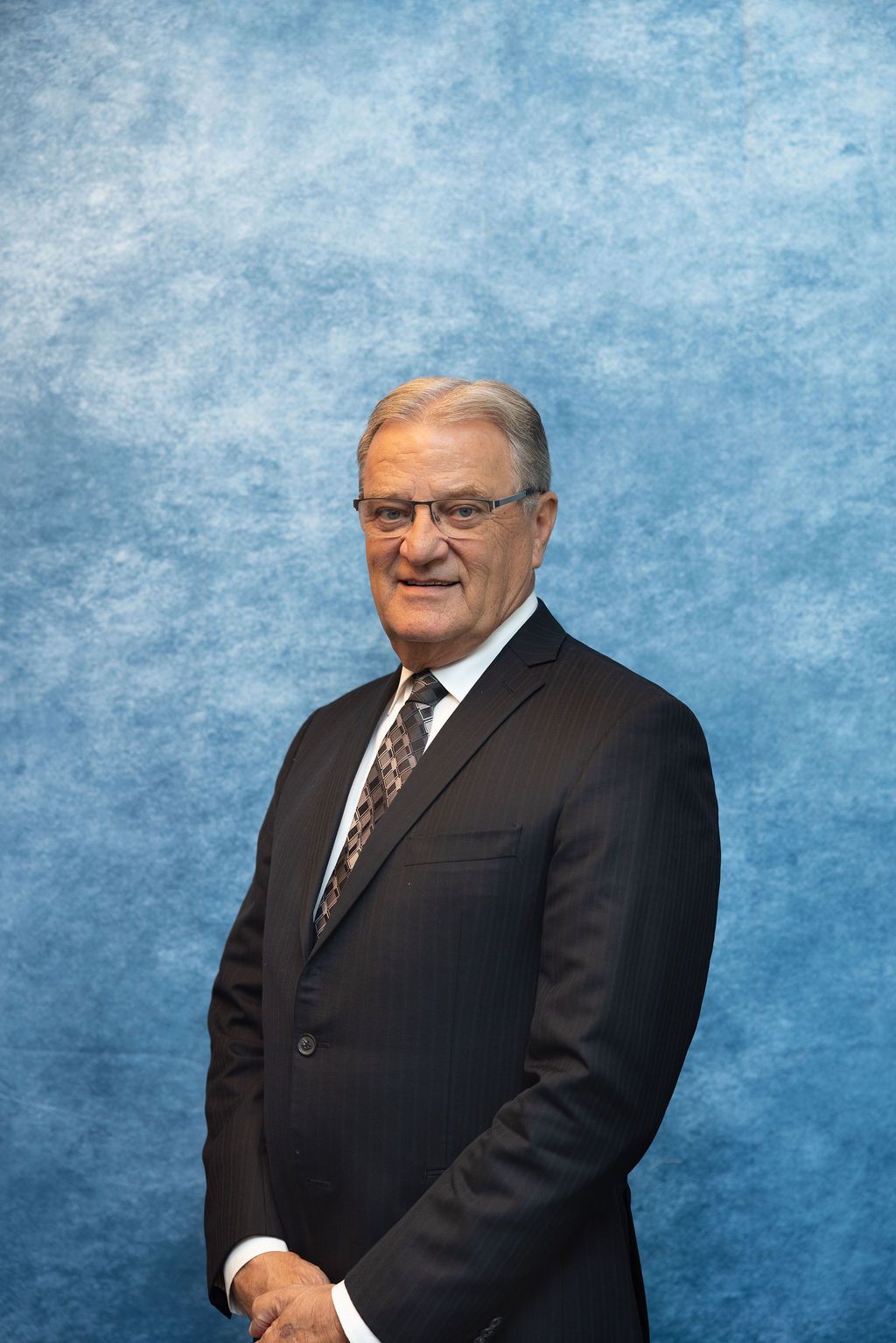 a man in a suit and tie is smiling for the camera .