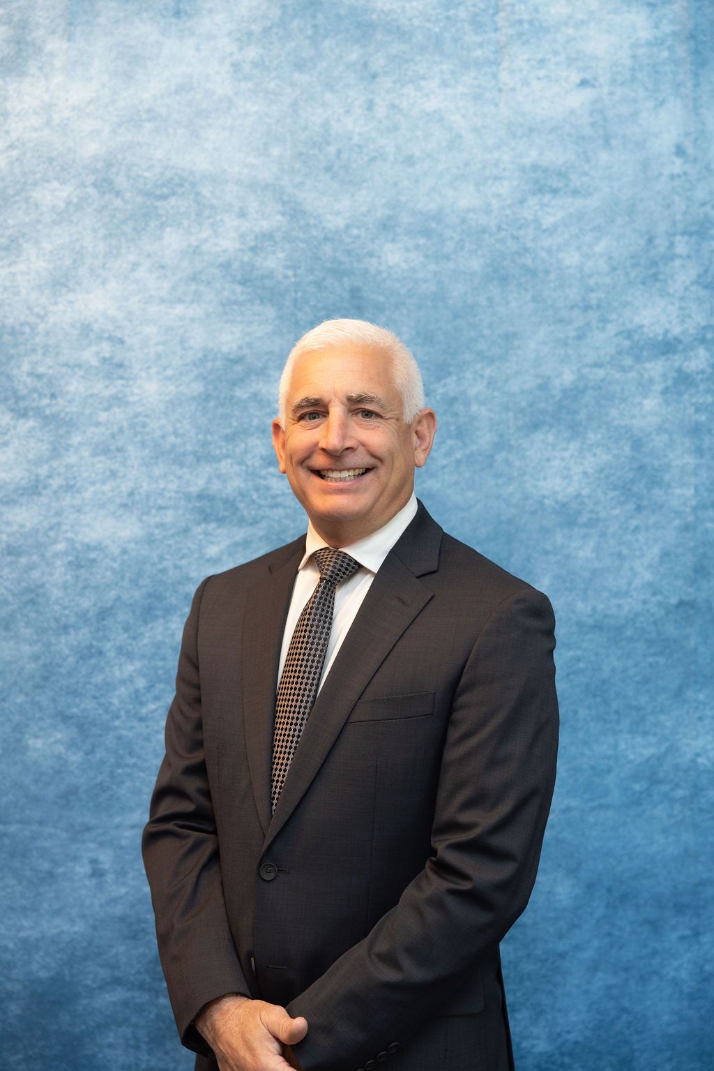 a man in a suit and tie is smiling for the camera