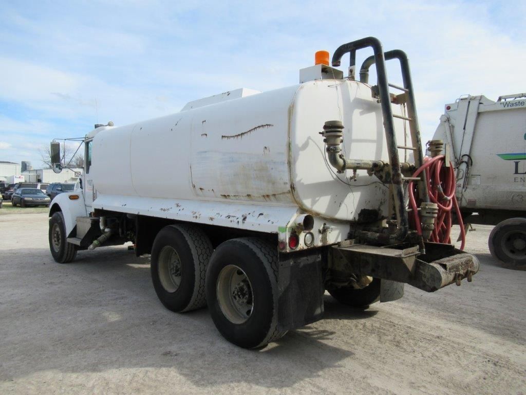 White tanker truck parked outside.