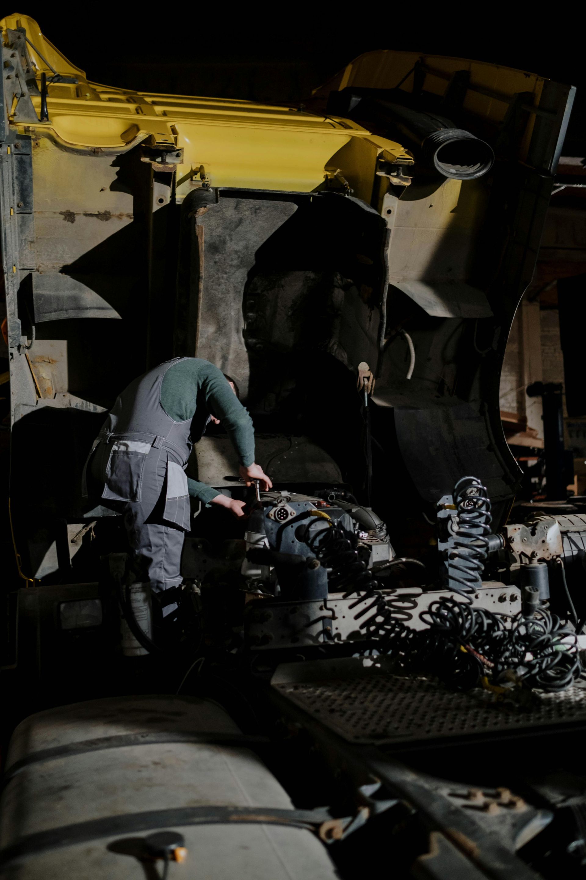 Two men are working on a truck at night.
