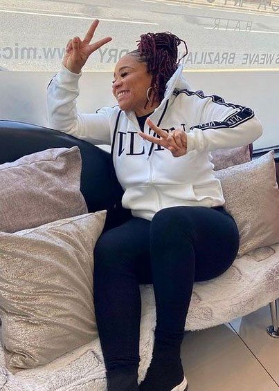 Woman with red dreads making a peace sign with her hand