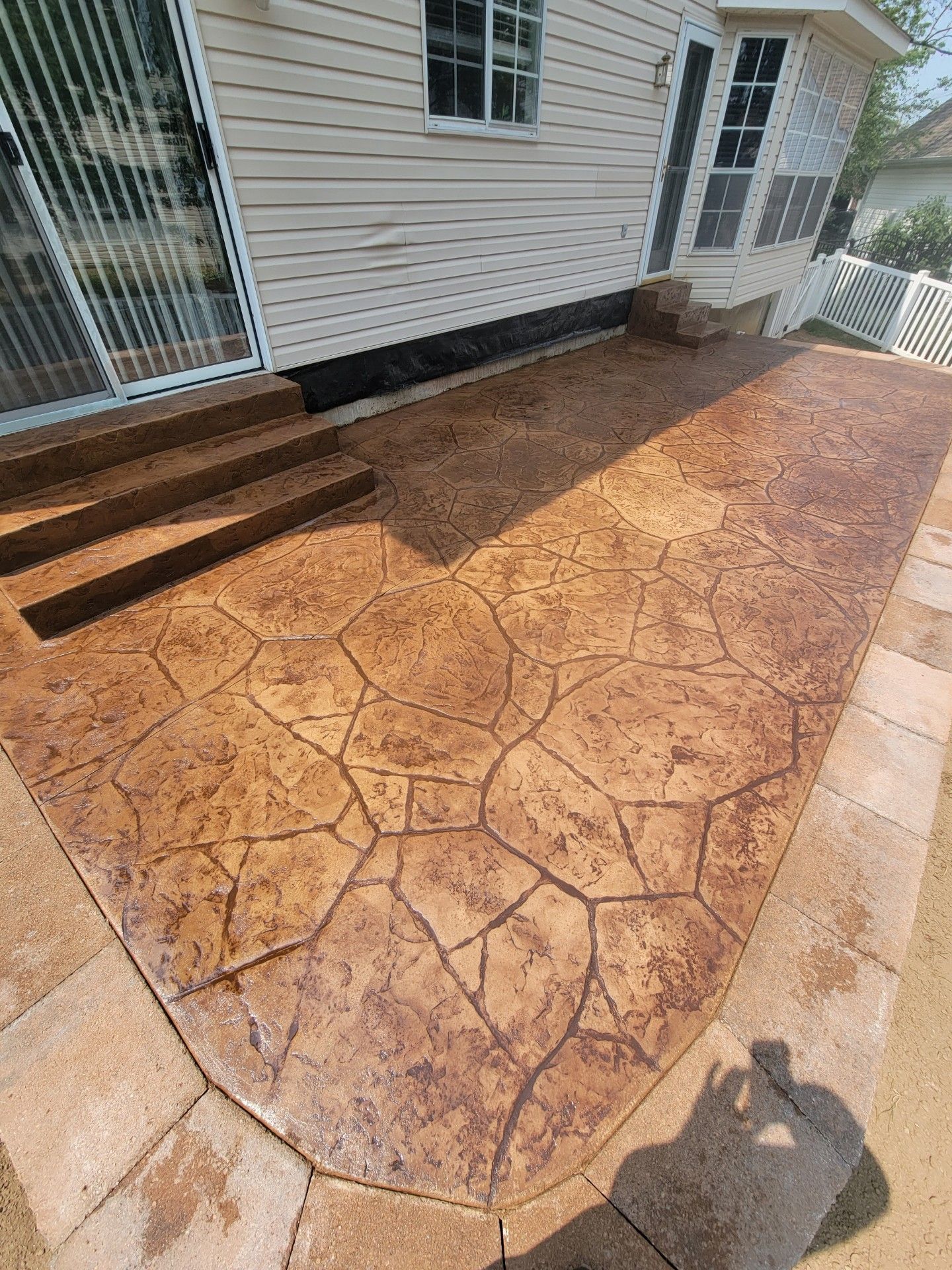 a concrete patio with steps leading to a house .