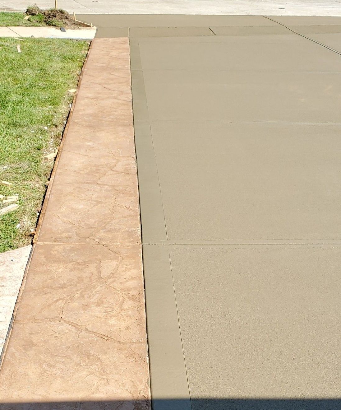 a concrete driveway with a sidewalk next to it