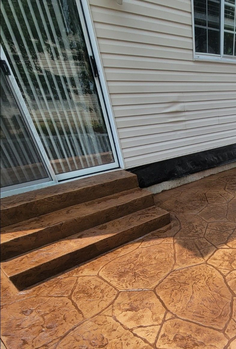 a house with a sliding glass door and steps leading to it .