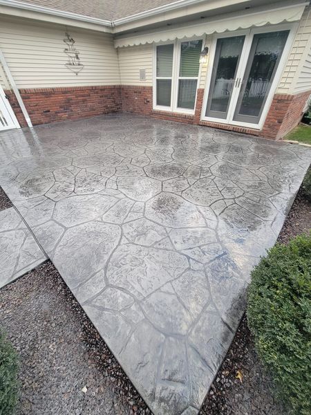 a concrete patio in front of a house with sliding glass doors .