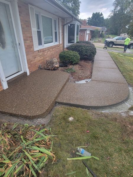 a brick house with a concrete walkway in front of it .