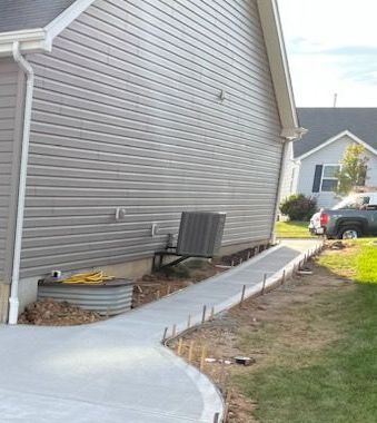 a concrete walkway is being built in front of a house .