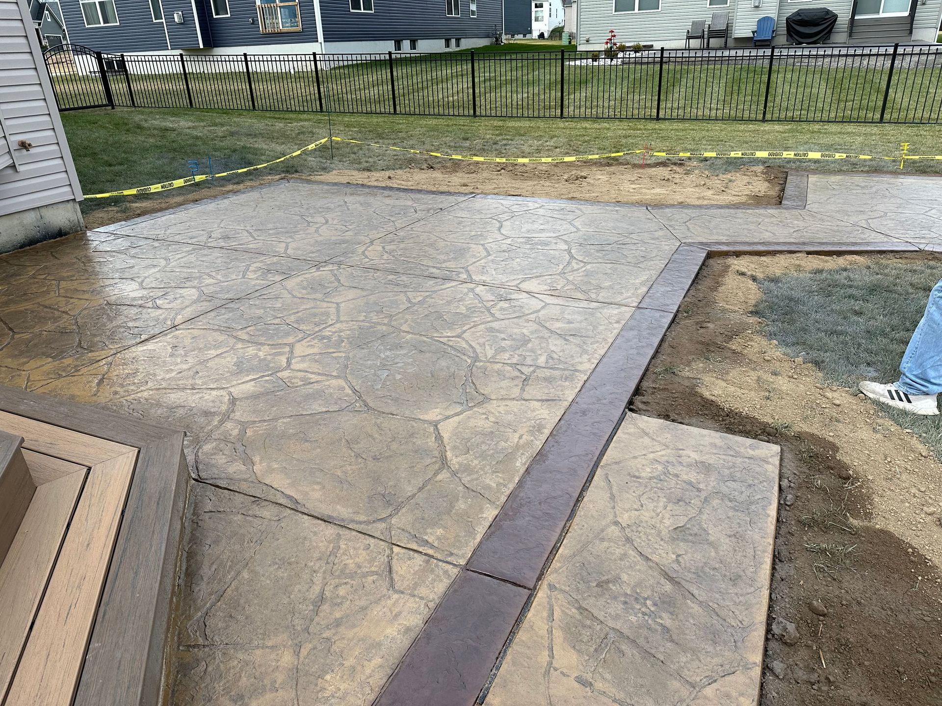 a person is standing on a concrete patio in front of a house .