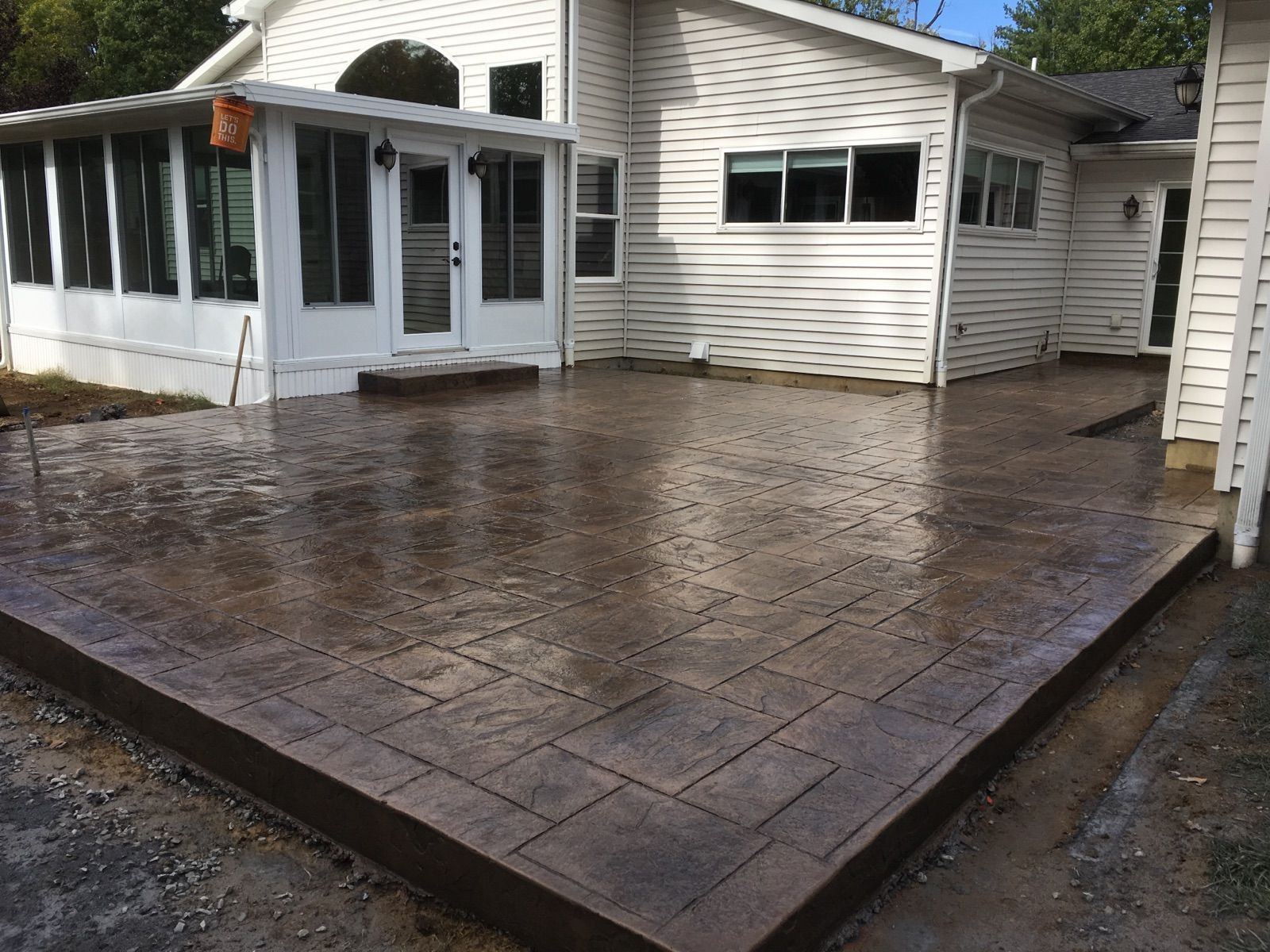a large concrete patio in front of a white house .