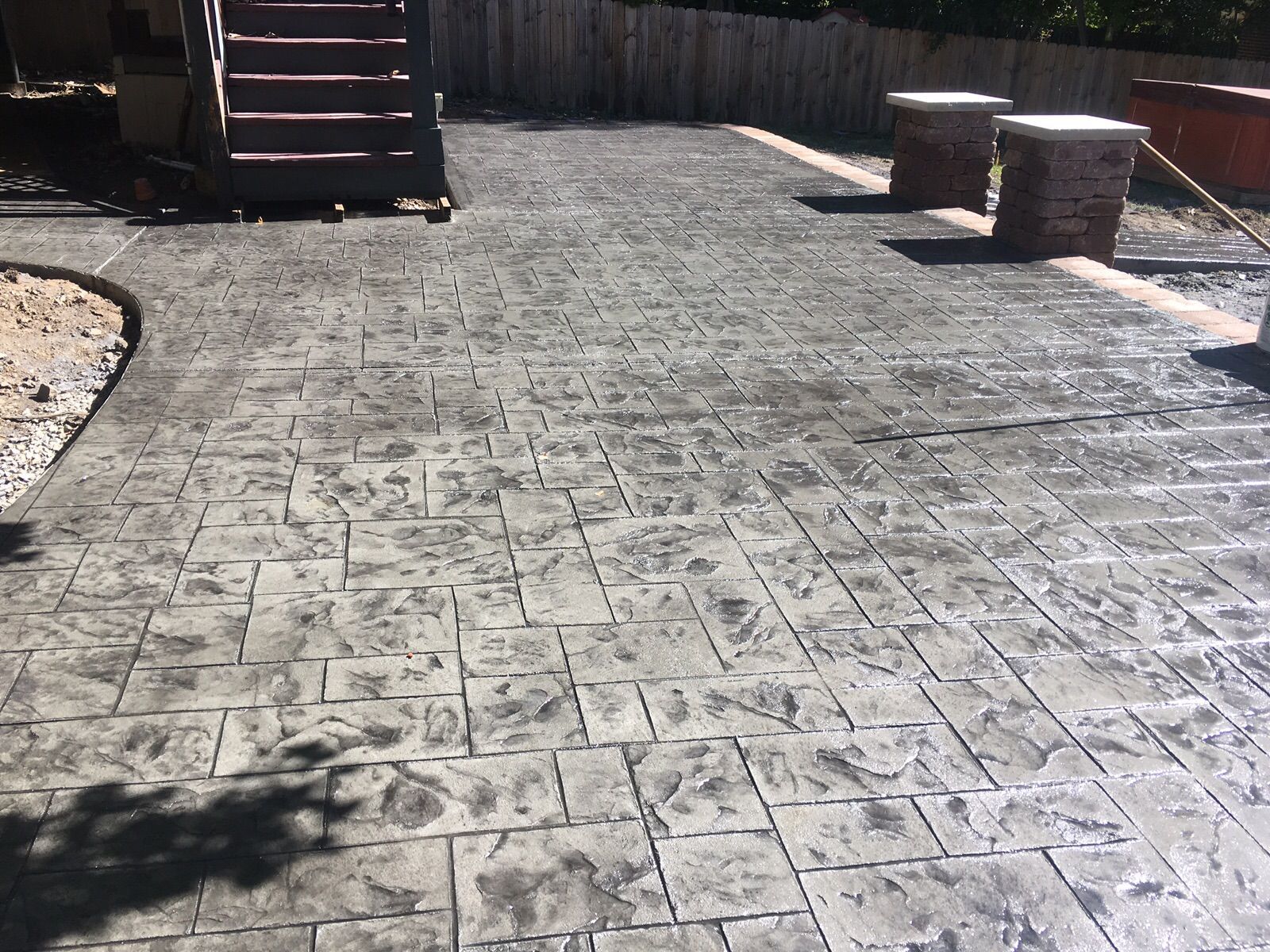 a concrete patio with stairs and benches in a backyard .