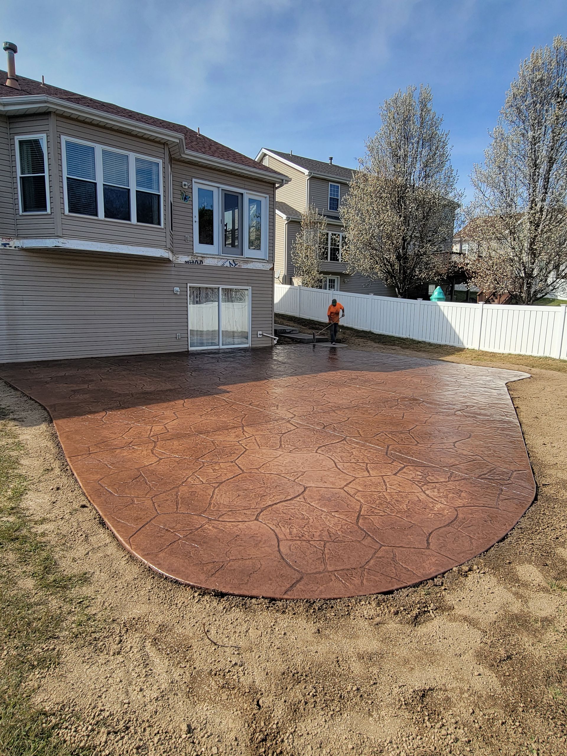 a backyard with a concrete patio in front of a house .