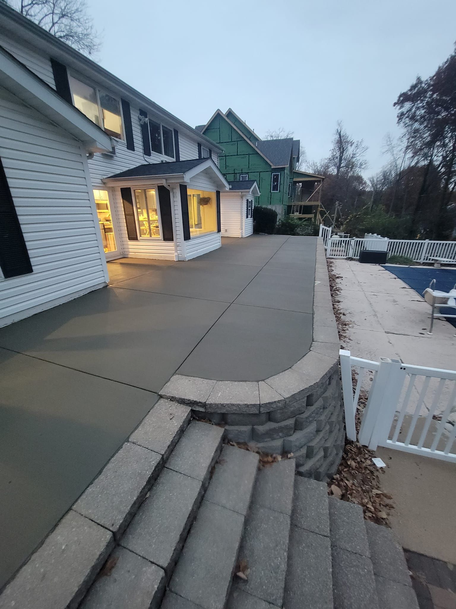 a concrete driveway leading to a house with stairs leading up to it .