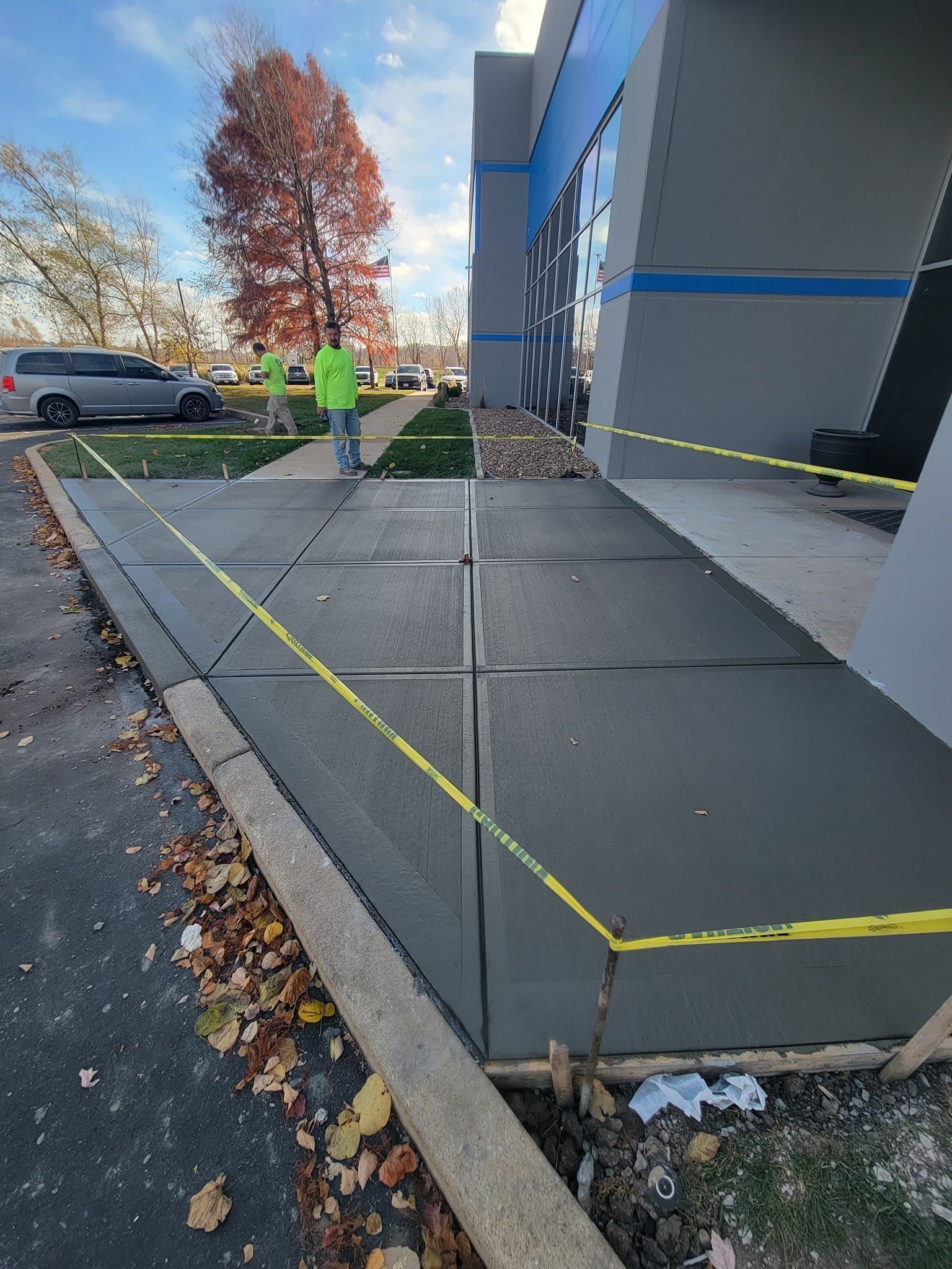 a man is walking down a sidewalk next to a building .