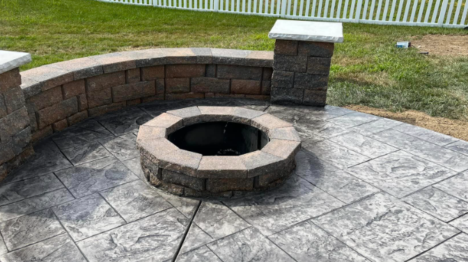 stamped concrete patio with seating wall and firepit