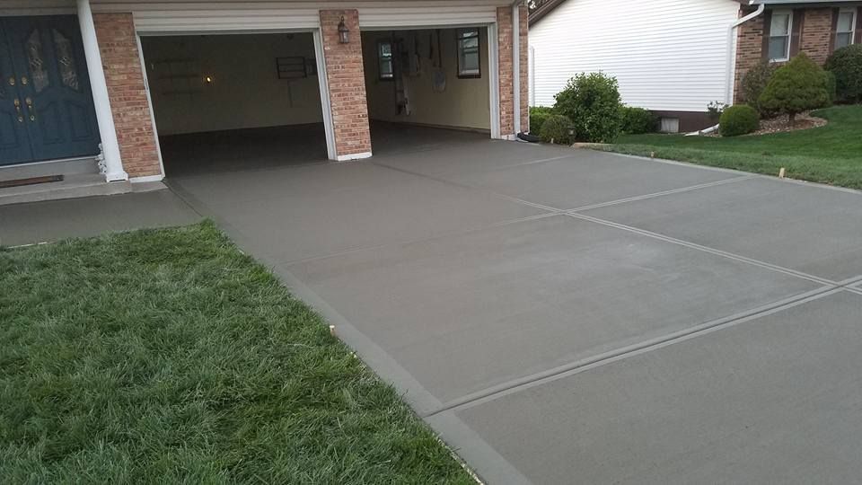 a concrete driveway leading to a garage next to a house .