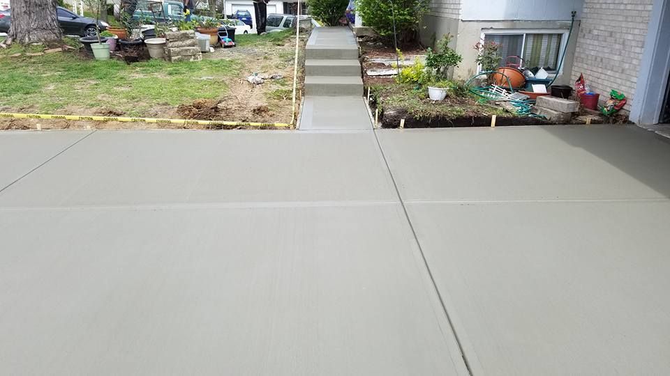 a concrete driveway with stairs leading up to a house .