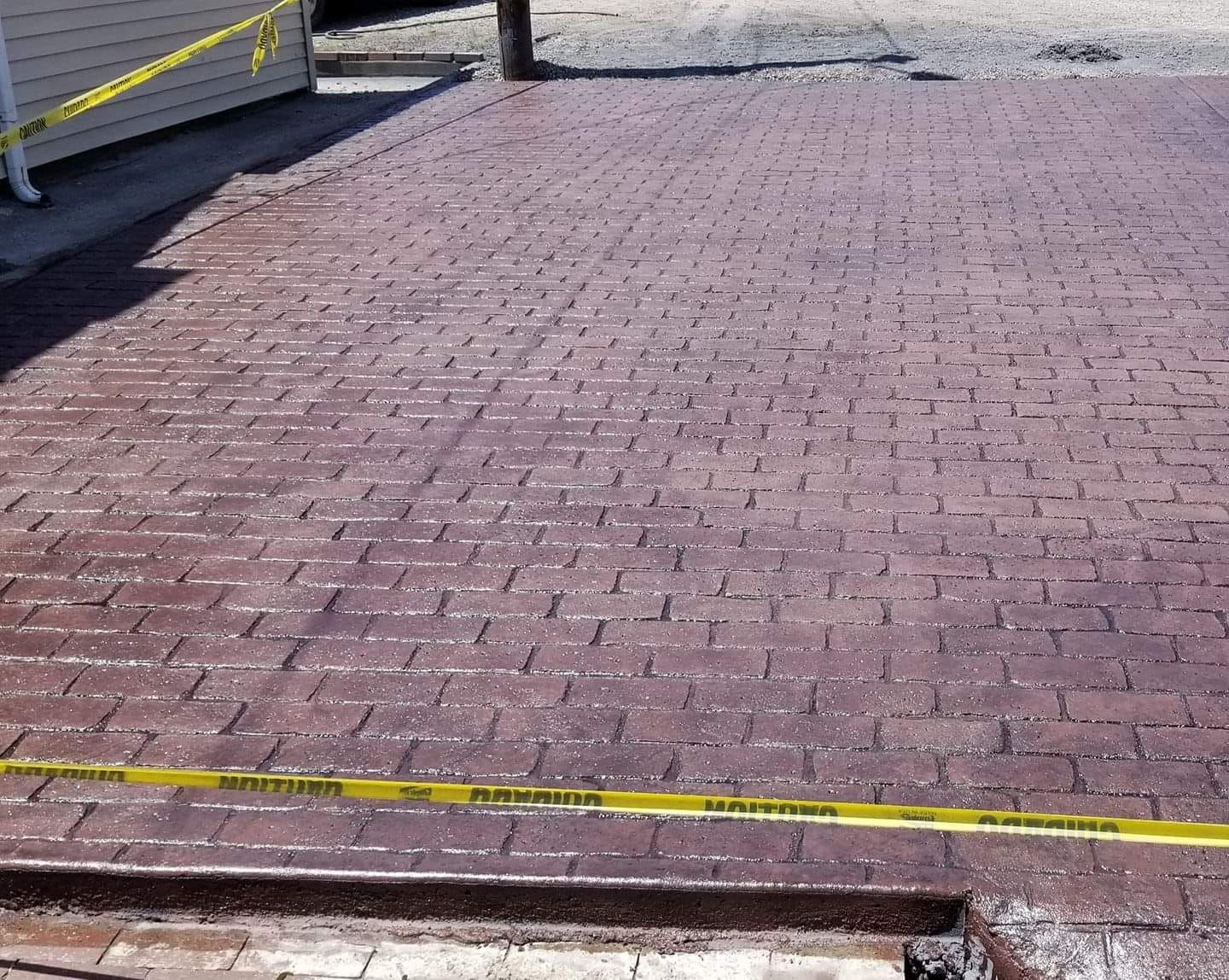 a brick driveway with a yellow tape around it