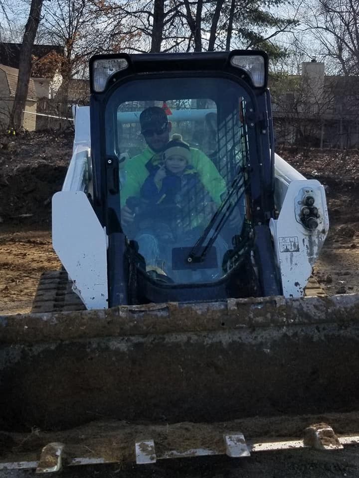 a man and two children are sitting in a bulldozer