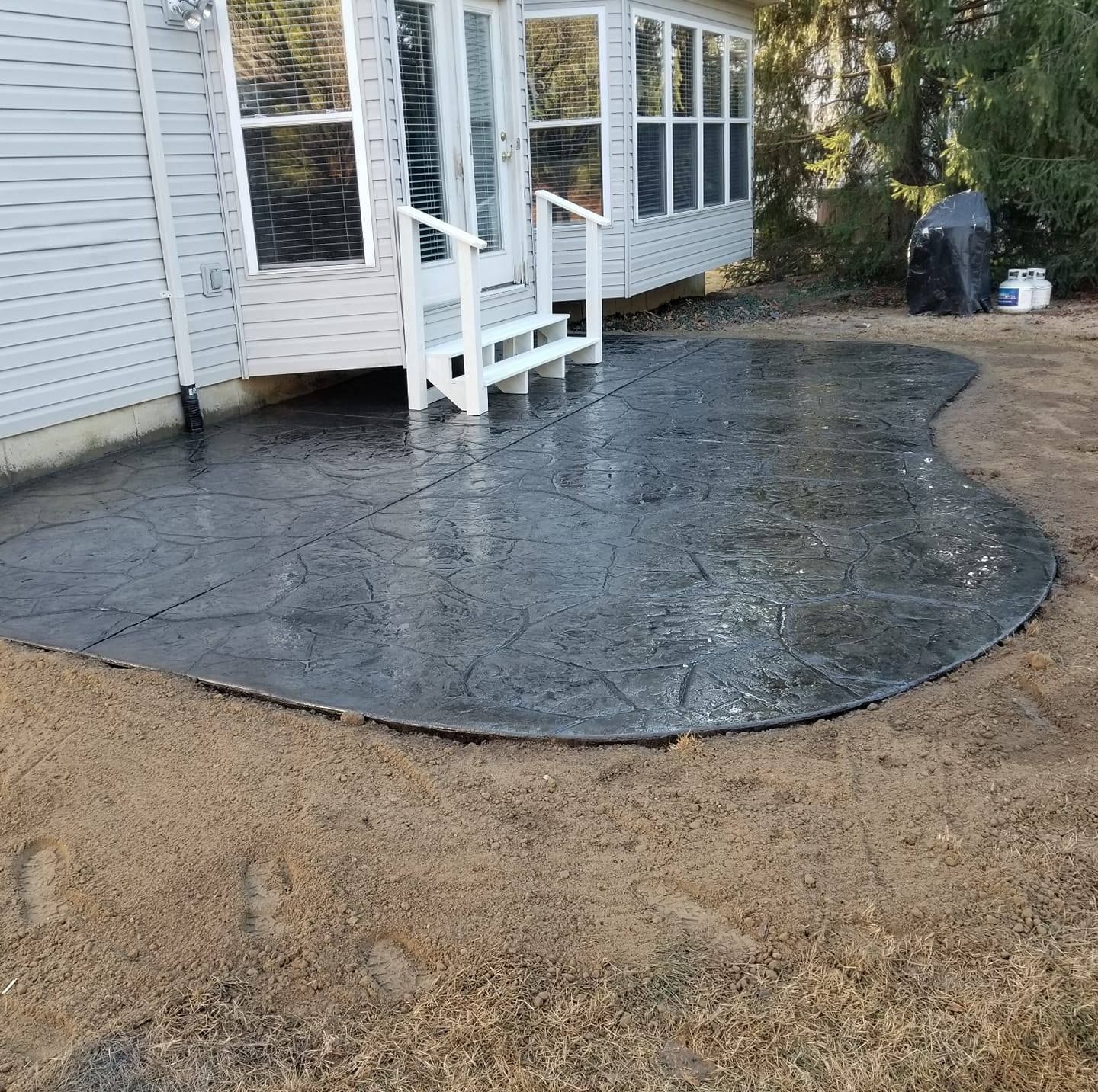 a concrete patio with stairs and a white house in the background .