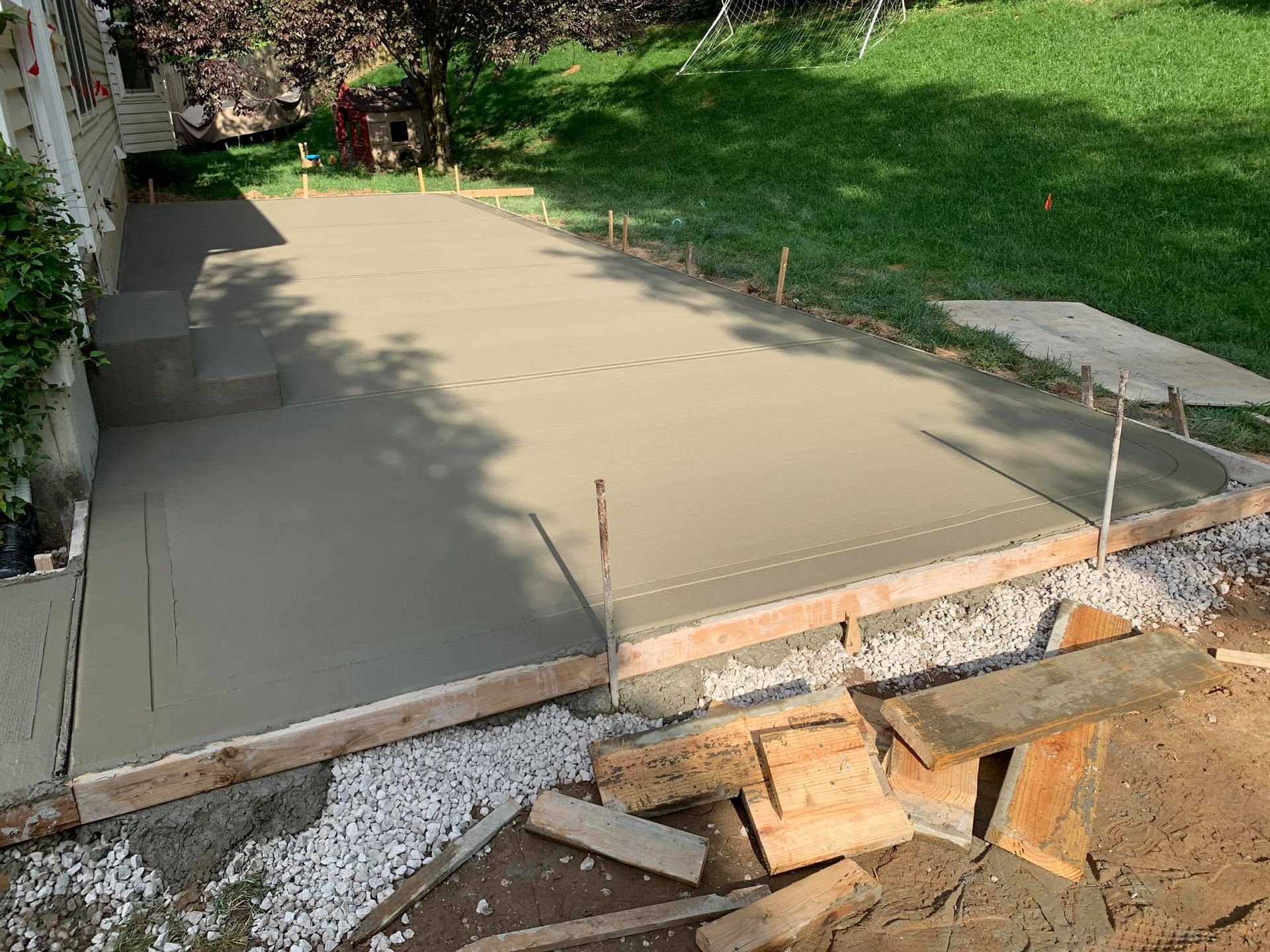 a concrete driveway is being built in the backyard of a house .