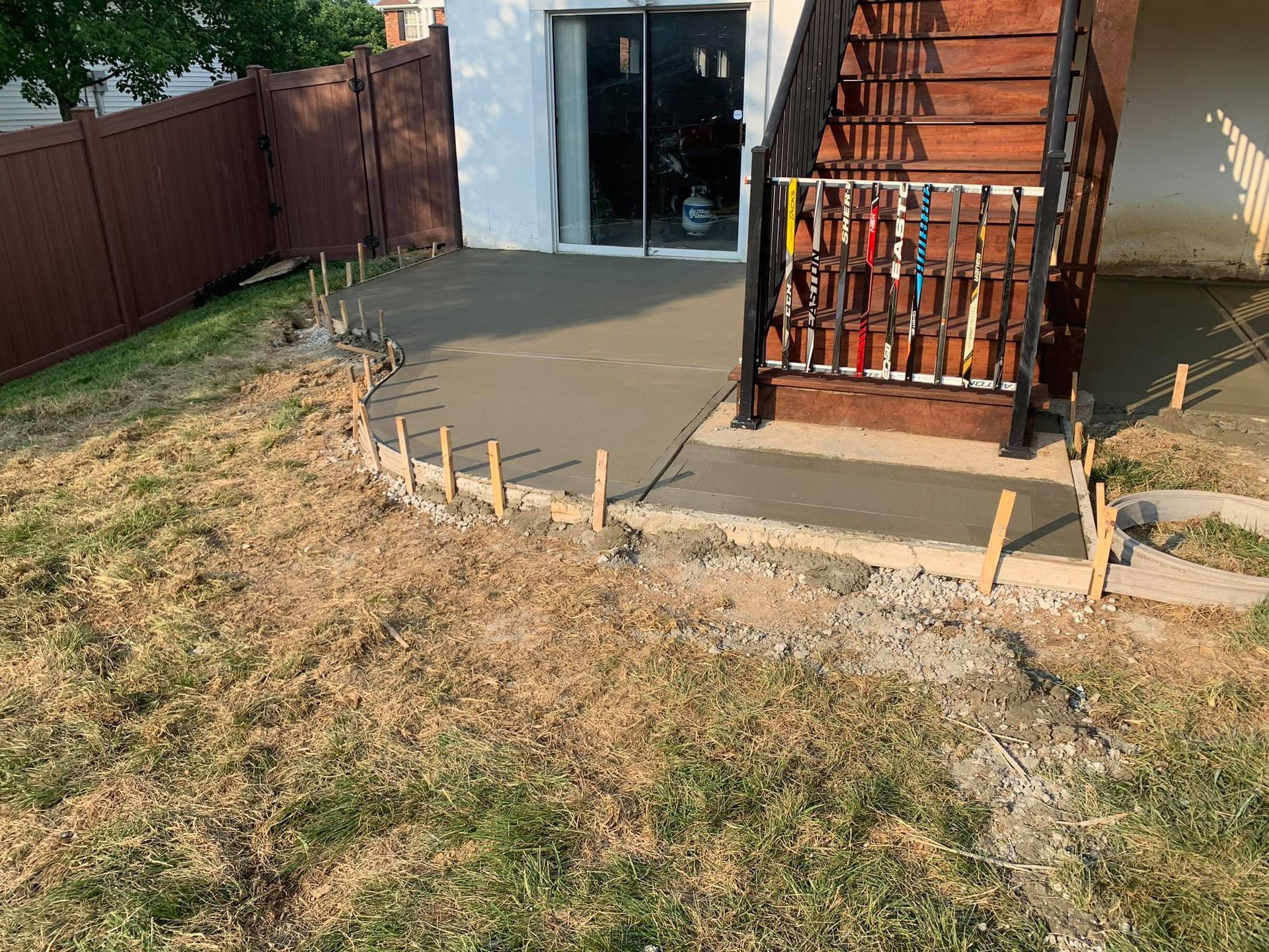 a concrete patio is being built in the backyard of a house .