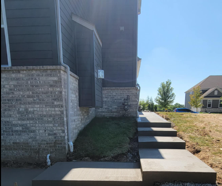 house with a concrete walkway leading to it . L & S Concrete STL