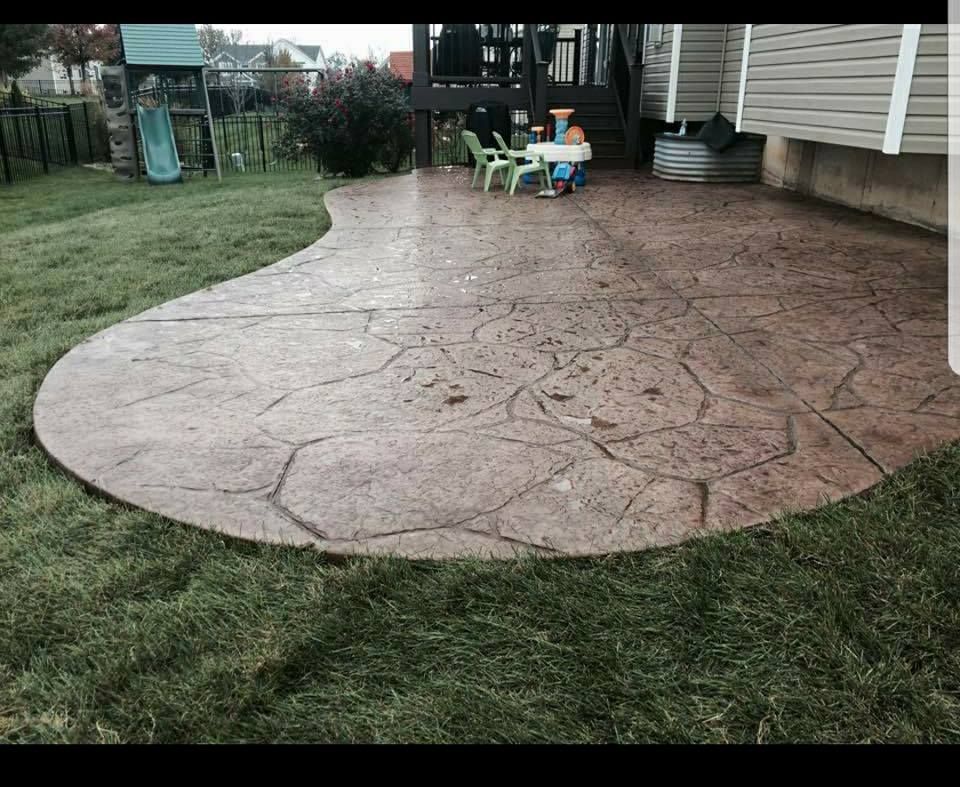 a patio with a table and chairs on it in a backyard .