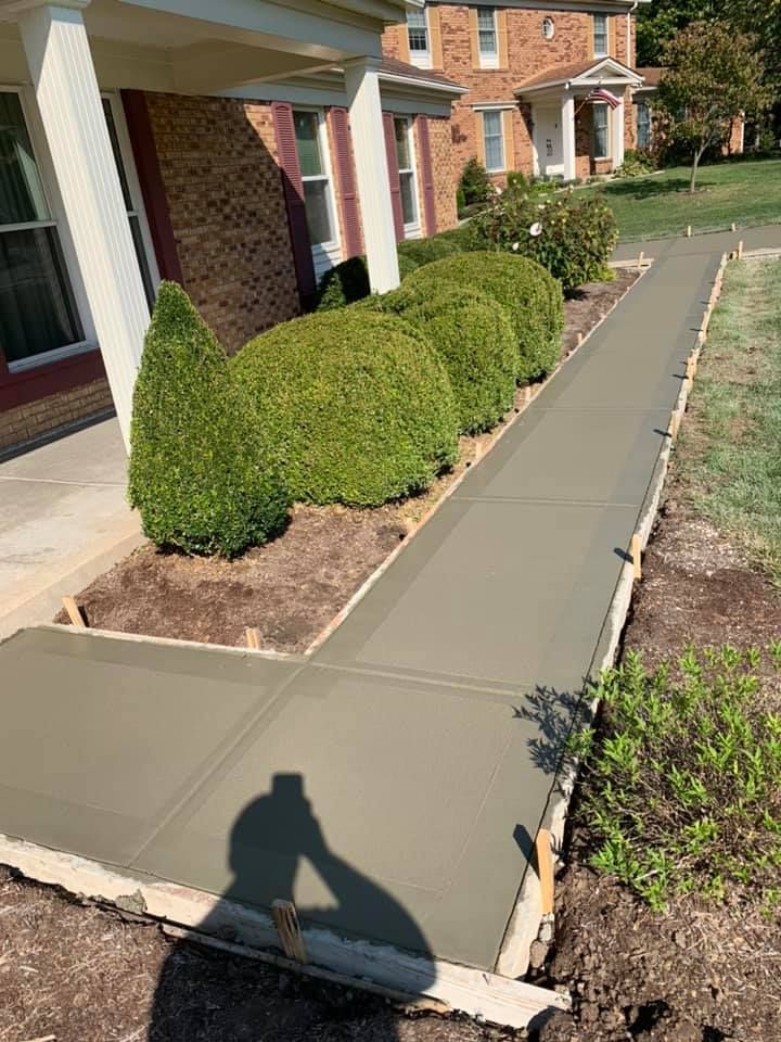a concrete walkway is being built in front of a house .