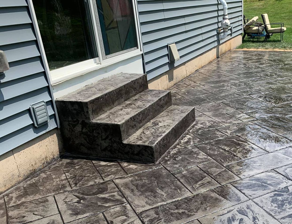 a concrete patio with stairs leading up to a house .