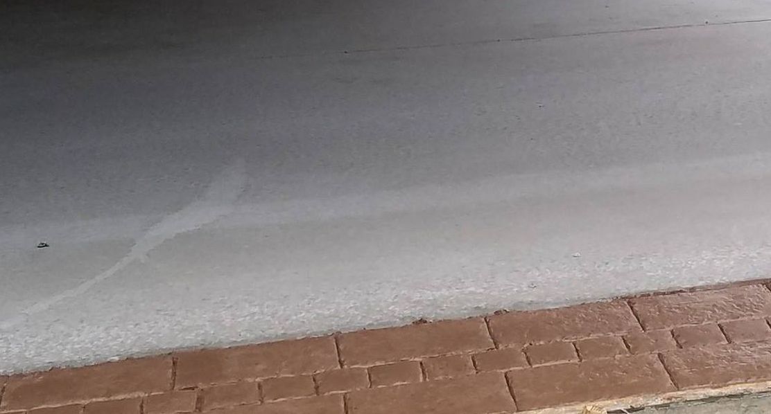 A close up of a brick walkway with snow on the ground.