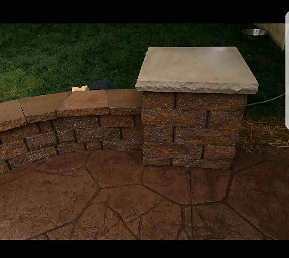 a brick wall with a stone pillar in the middle of it .