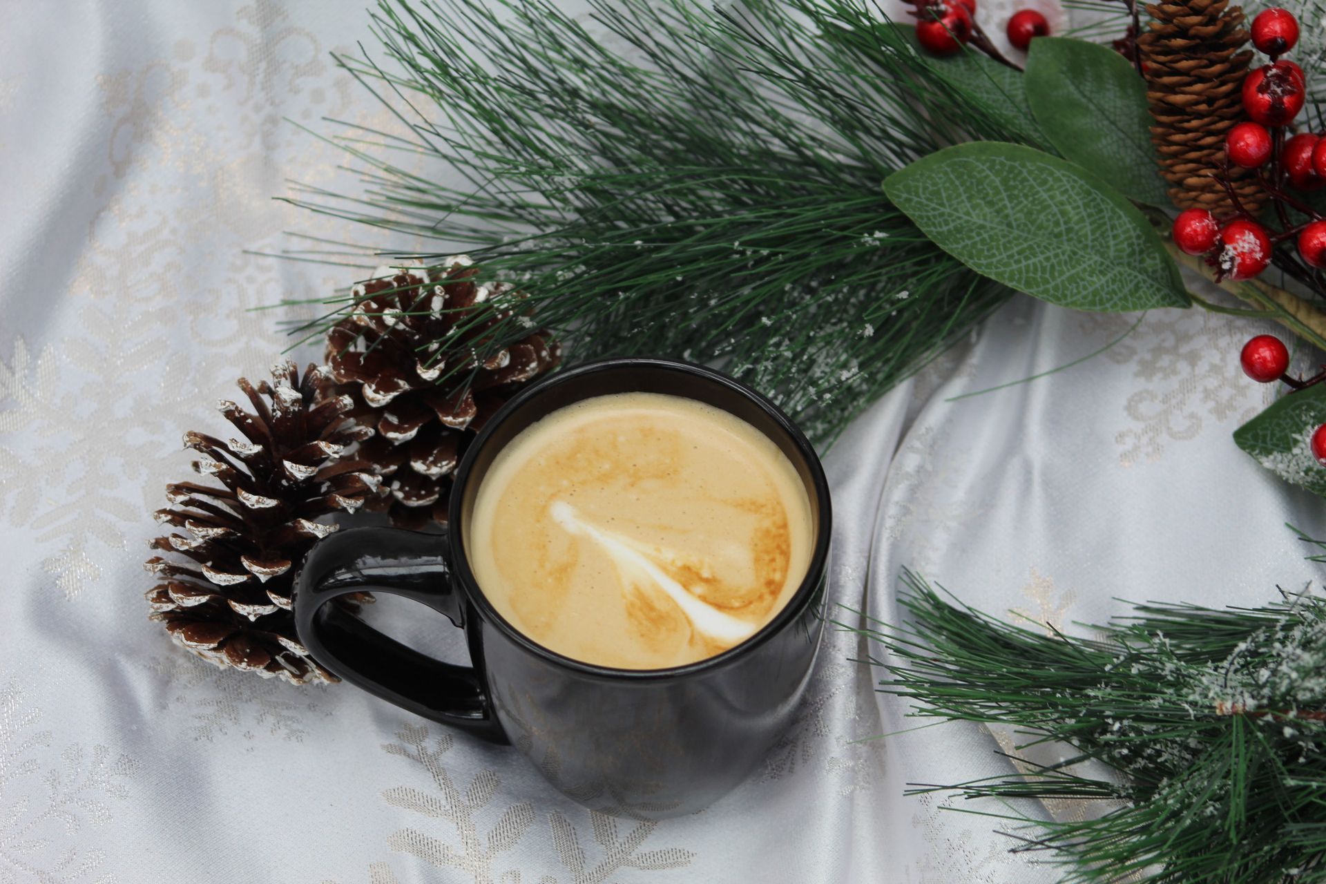 Chocolate chip cookies on a wooden serving platter, sitting on a black table with greenery in the background.