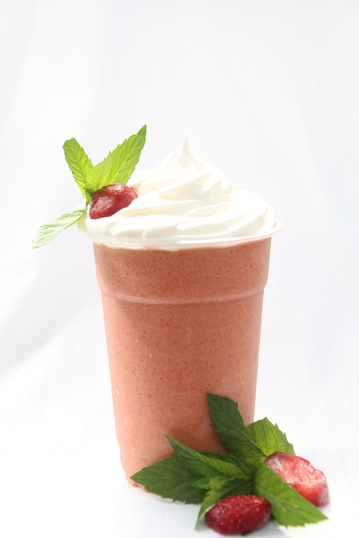 A cup of milkshake with whipped cream and red bubbles