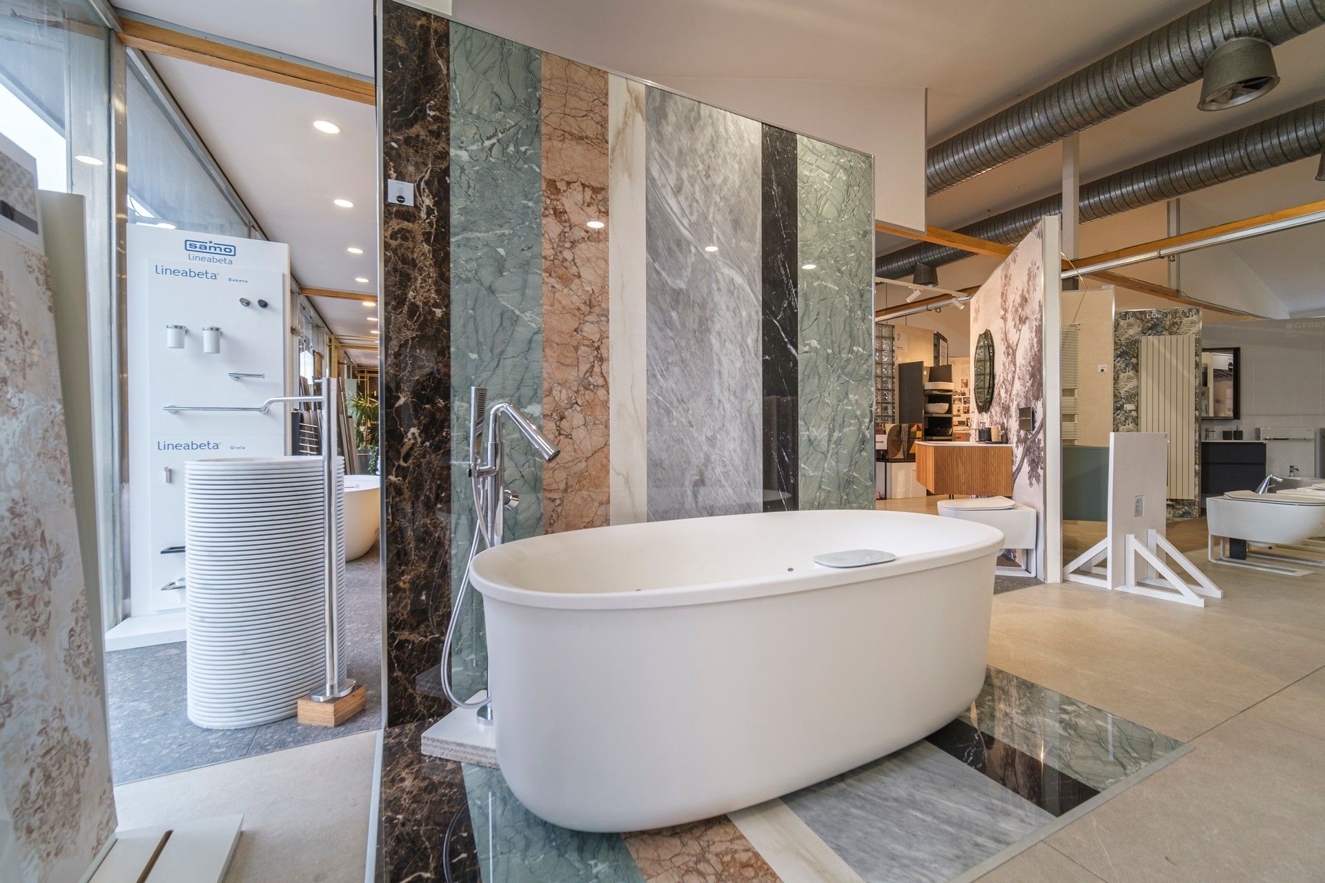 C'è una vasca da bagno al centro della stanza in uno showroom di bagni.