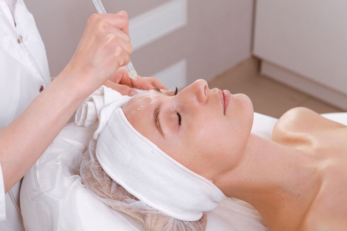 Woman receiving facial treatment in a spa, lying down with eyes closed.