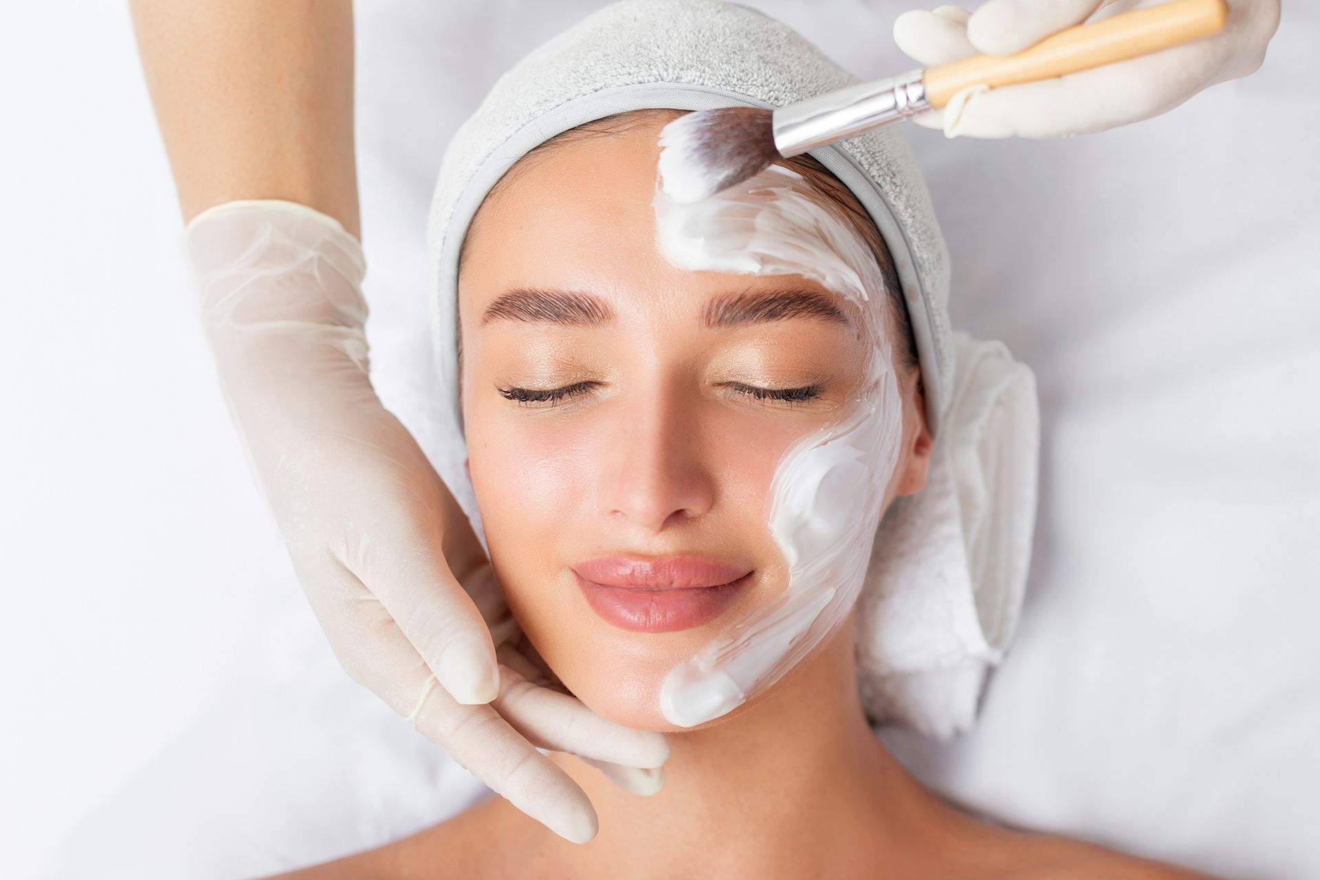 Woman receiving a facial mask application at a spa.