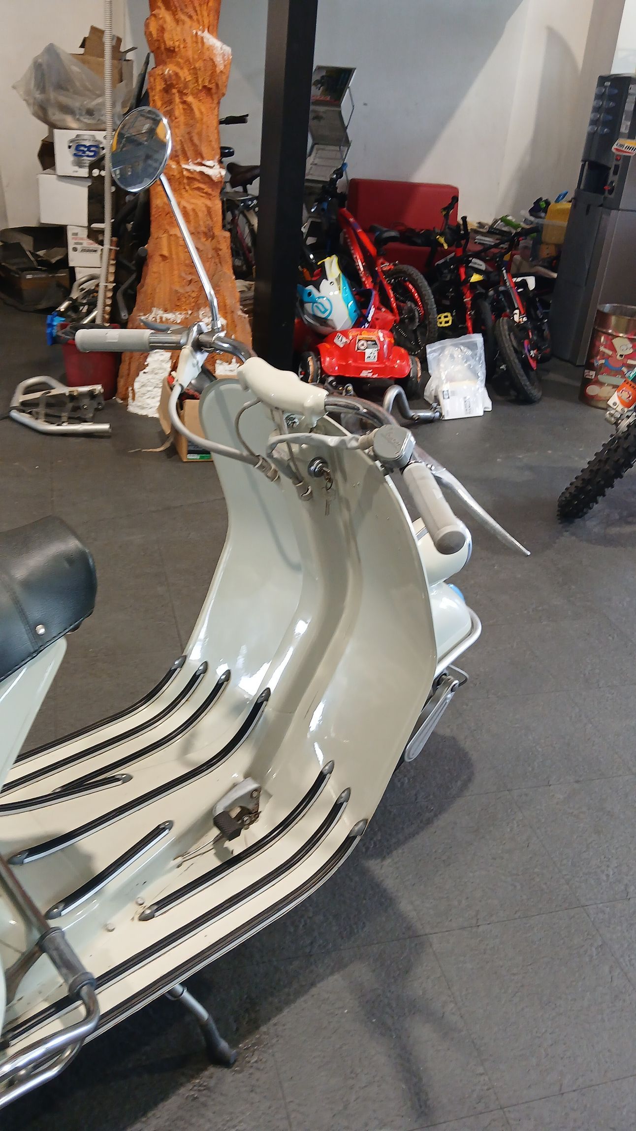 Scooter d'epoca grigio chiaro in un'officina.