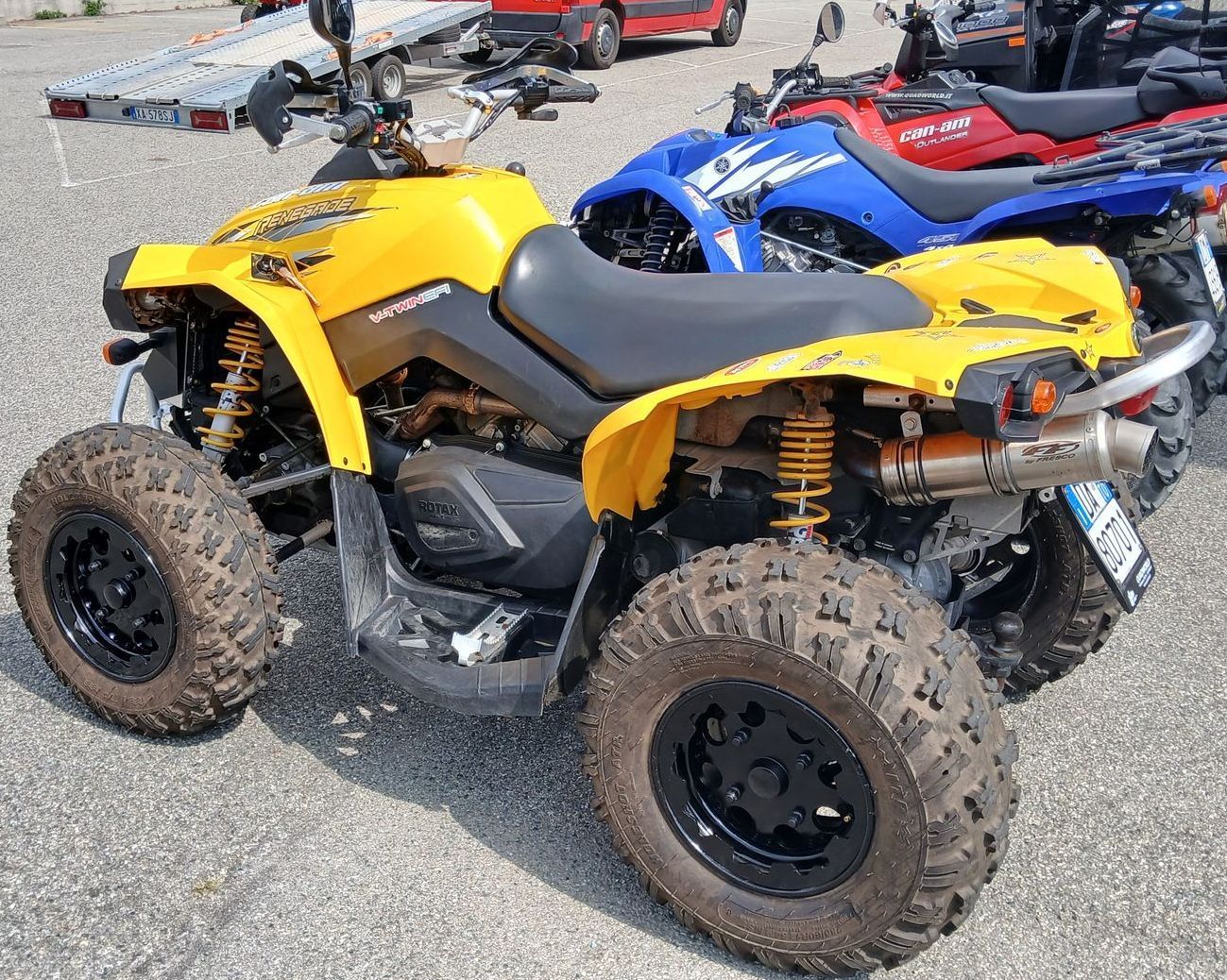 Quad giallo parcheggiato insieme ad altri quad.
