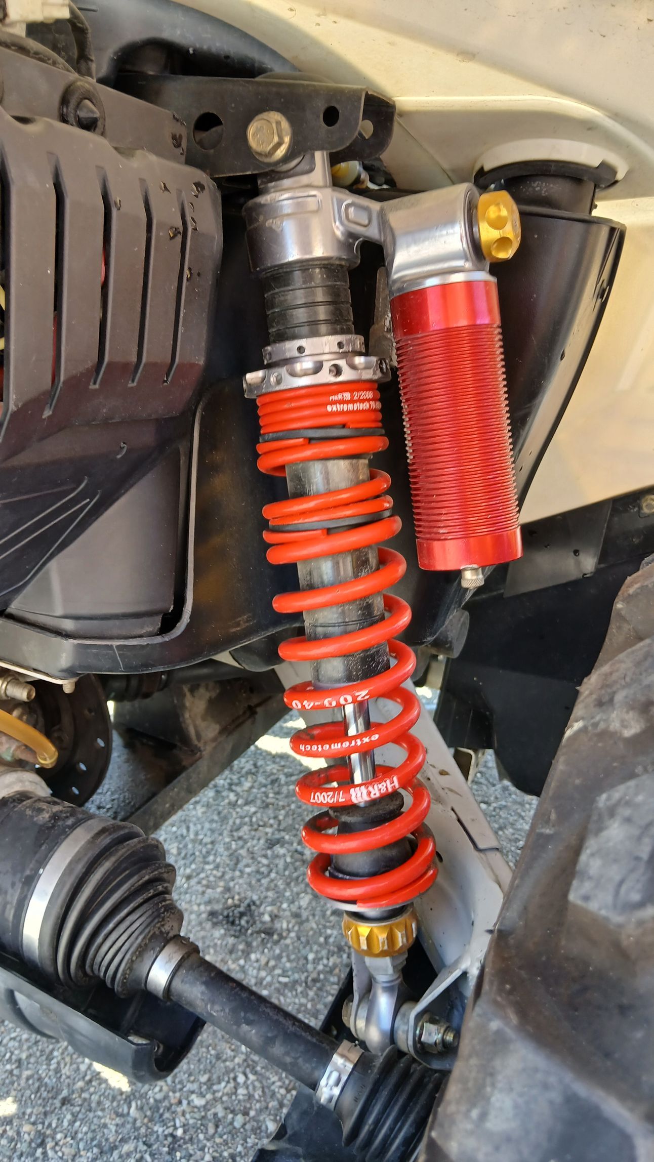 Ammortizzatore ATV rosso e argento installato su un veicolo.