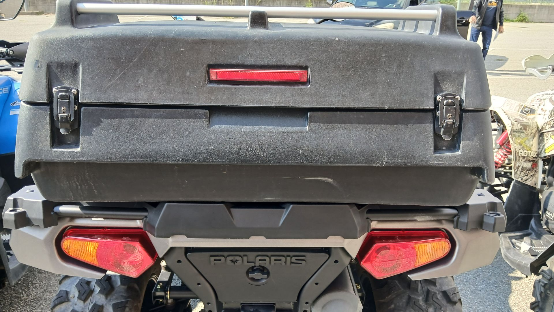 Vista posteriore di un ATV Polaris nero con vano portaoggetti e luci posteriori rosse.
