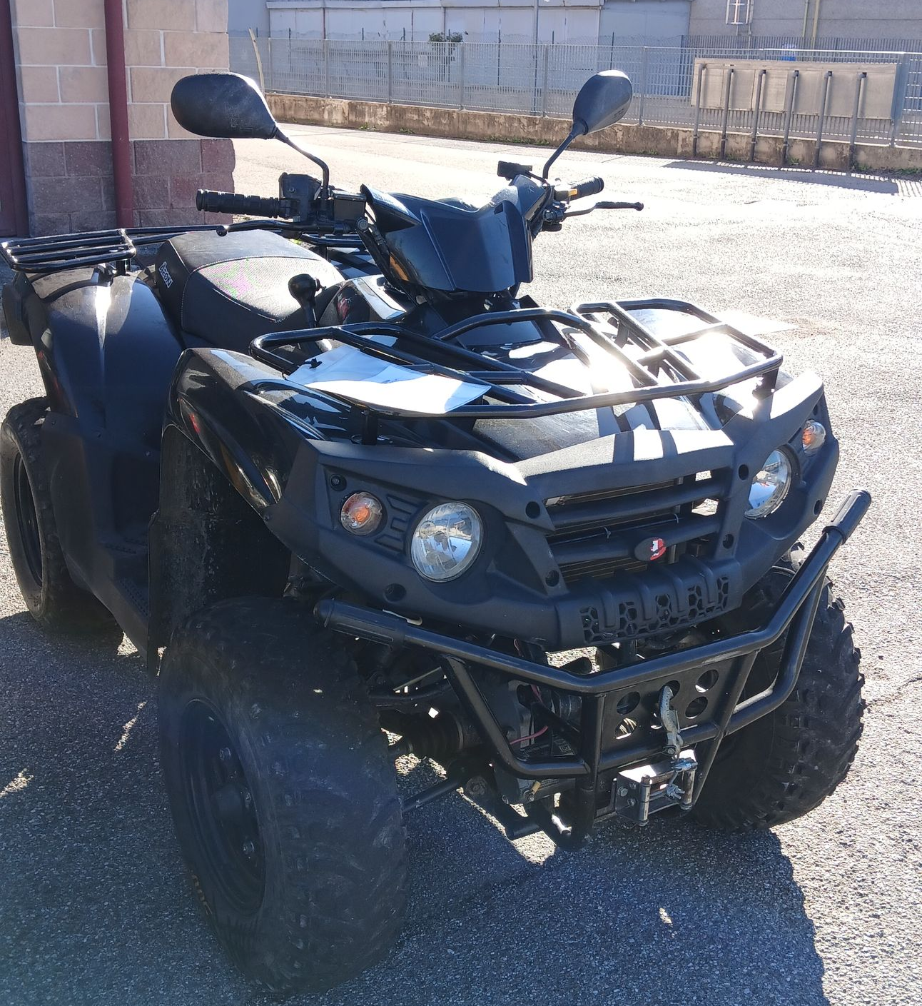 Veicolo fuoristrada (ATV) nero parcheggiato all'aperto in una giornata di sole.