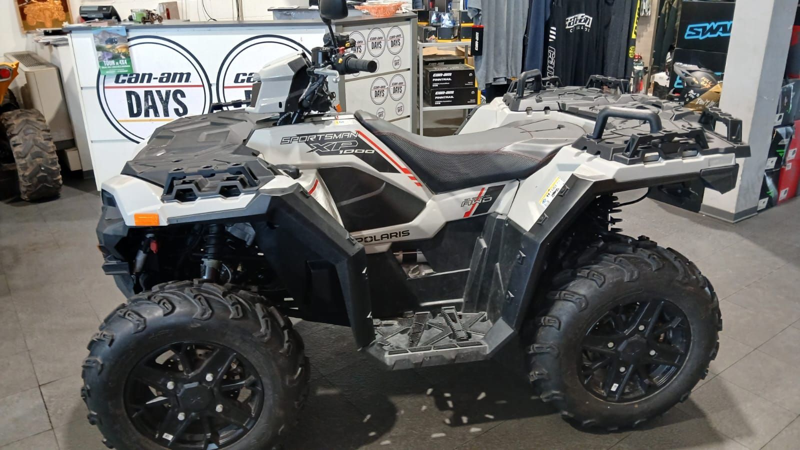 Un quad Polaris grigio e nero parcheggiato all'interno di un negozio.