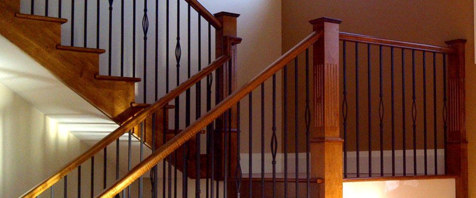 Wooden staircase with black metal railings and decorative accents.