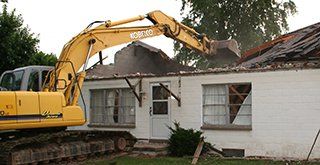 excavator demolishing a house