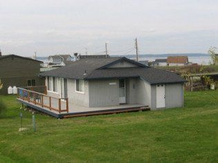 A small house with a deck and a view of the ocean