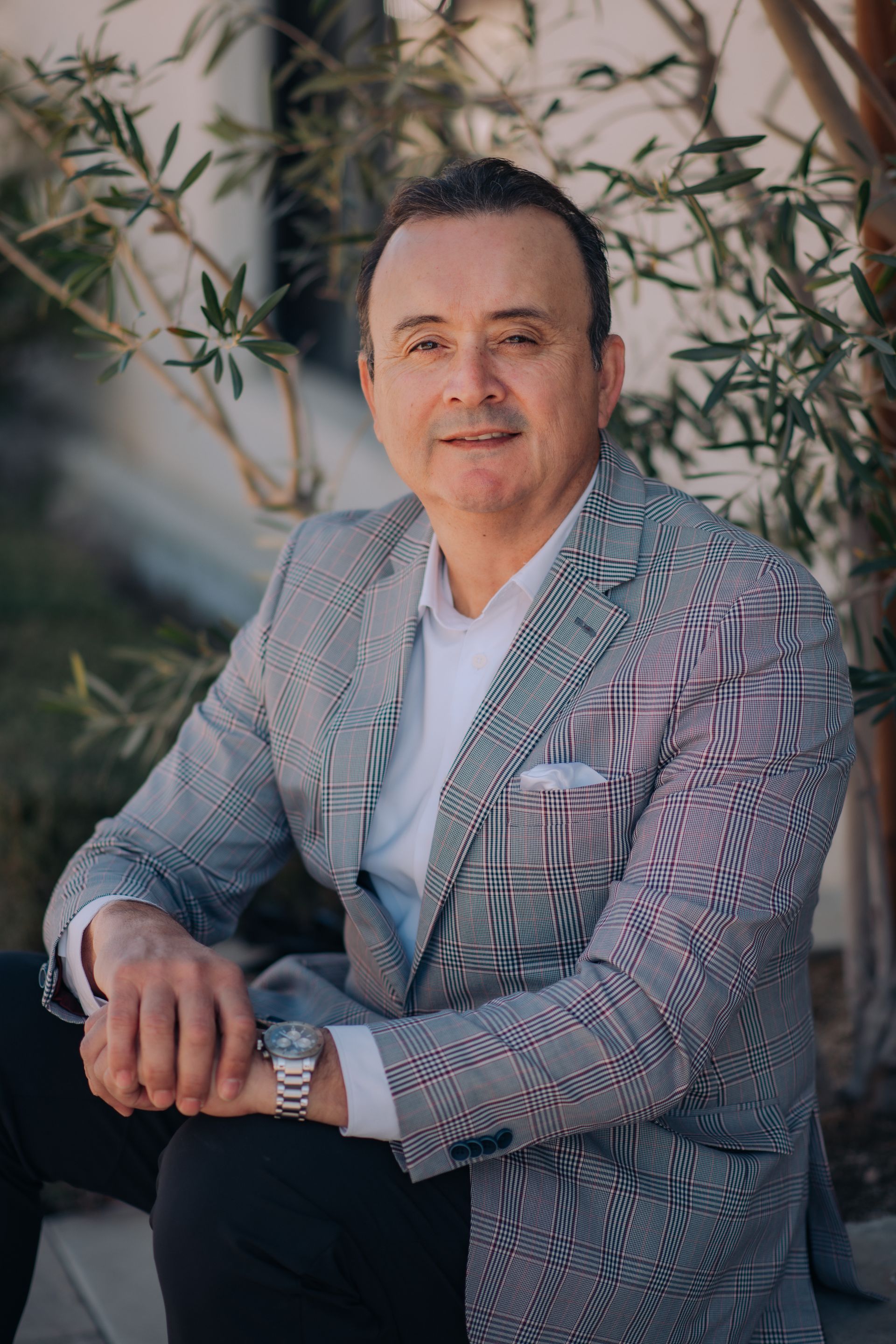 A man in a suit and tie is sitting on a bench.