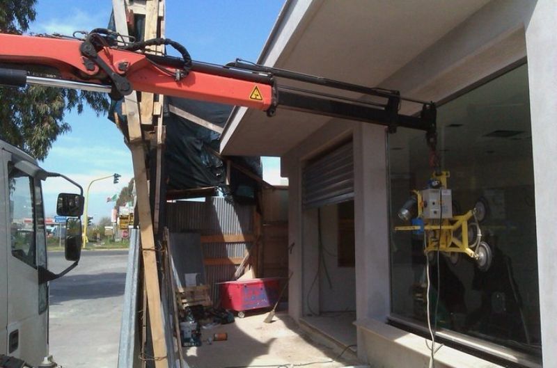 Autogrù con braccio verso un edificio